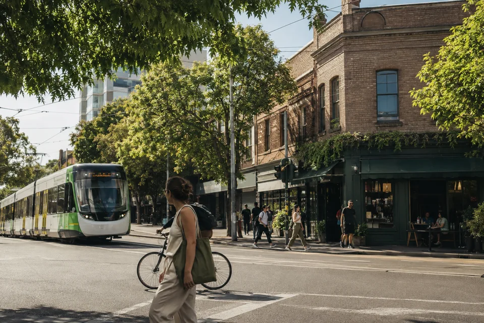 A Melbourne street with a tram, local shops, pedestrians and a cyclist