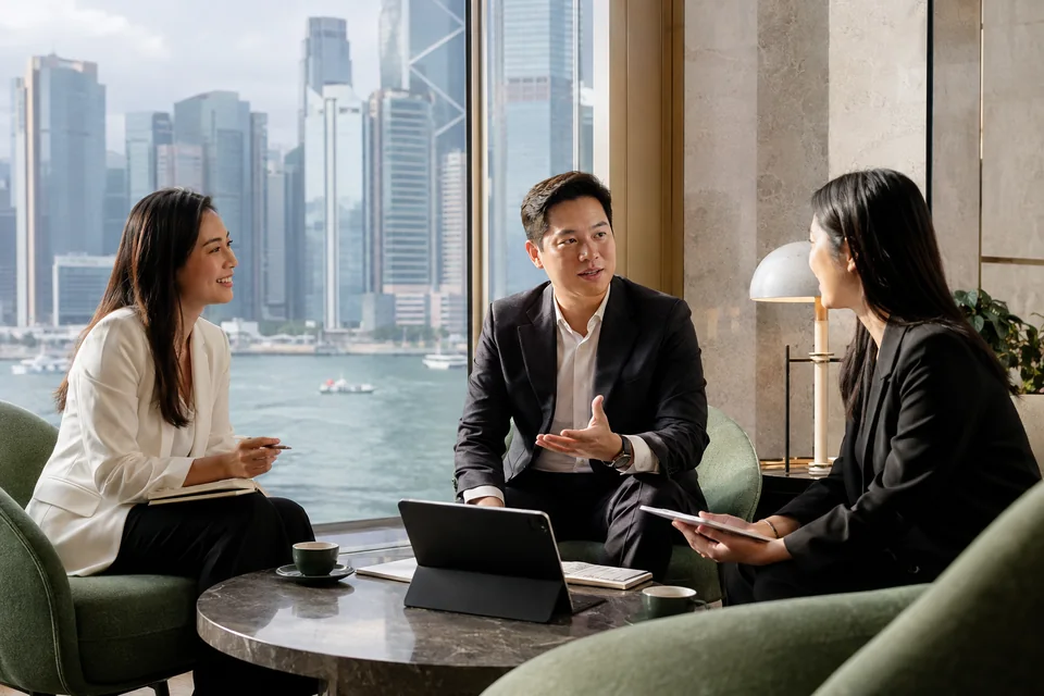 Business professionals discussing a project in a Hong Kong office overlooking the harbour