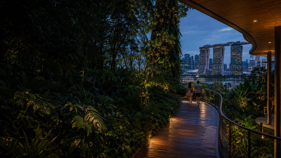 An imagined Singapore sky garden with a winding timber path, two people and Marina Bay beyond