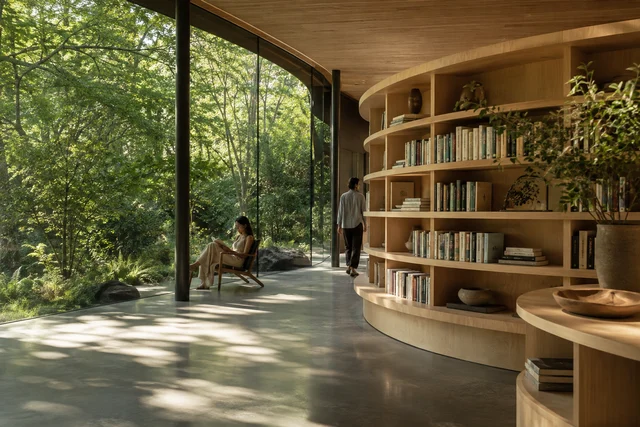 Readers exploring a contemporary timber library that opens into a green garden